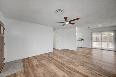 Unfurnished living room with ceiling fan, a textur