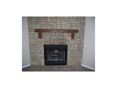 Close up of corner, wood-burning fireplace.