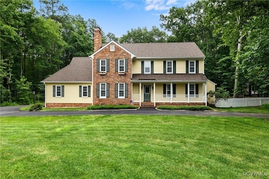 Colonial house featuring a porch, a chimney, drive