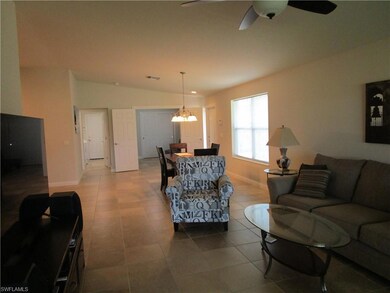 Tiled living area with ceiling fan with notable ch
