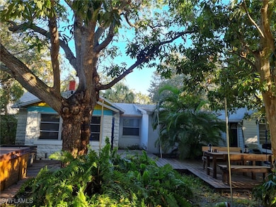 Rear view of house featuring stone siding and a wo