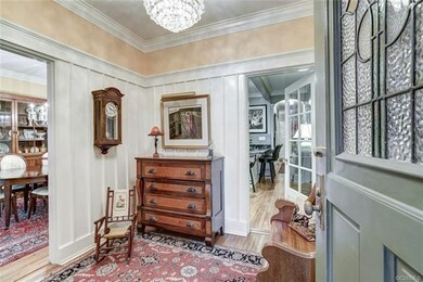 Beautiful glass front door and Foyer with paneling and coat closet.