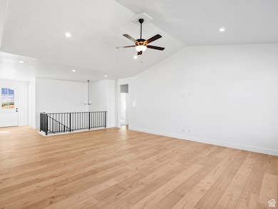 Spare room with light wood-style flooring, vaulted ceiling, recessed lighting, and a ceiling fan