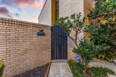 Charming entrance with a brick wall and a black wo