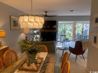 Living area with a fireplace, ceiling fan, and carpet floors