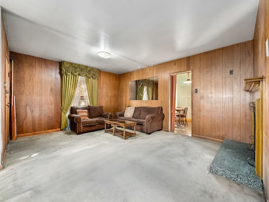 Living room featuring wood walls and baseboards
