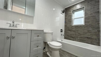 Bathroom featuring vanity, tile walls, wood finish floors, and shower / tub combination