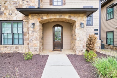 View of exterior entry featuring stone siding and 