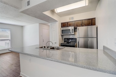 Kitchen with stainless steel appliances, sink, bac