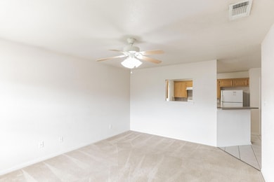 Empty room with a ceiling fan and light colored c