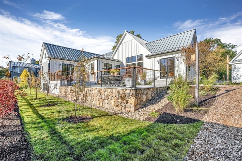 One of two newly constructed homes sits close by a renovated barn (visible at left) and another new house (at right). (The Attias Group via Homes.com)