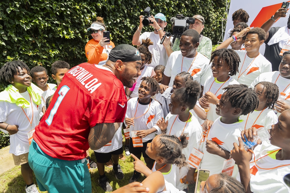 Miami Dolphins quarterback Tua Tagovailoa, in red practice jersey, surprised local youth from Boys &amp; Girls Clubs of Miami-Dade at the Gatorade “Get Fit for School” event last summer in Miami Gardens, Florida. (Jesus Aranguren for PepsiCo/AP Images via PR Newswire).