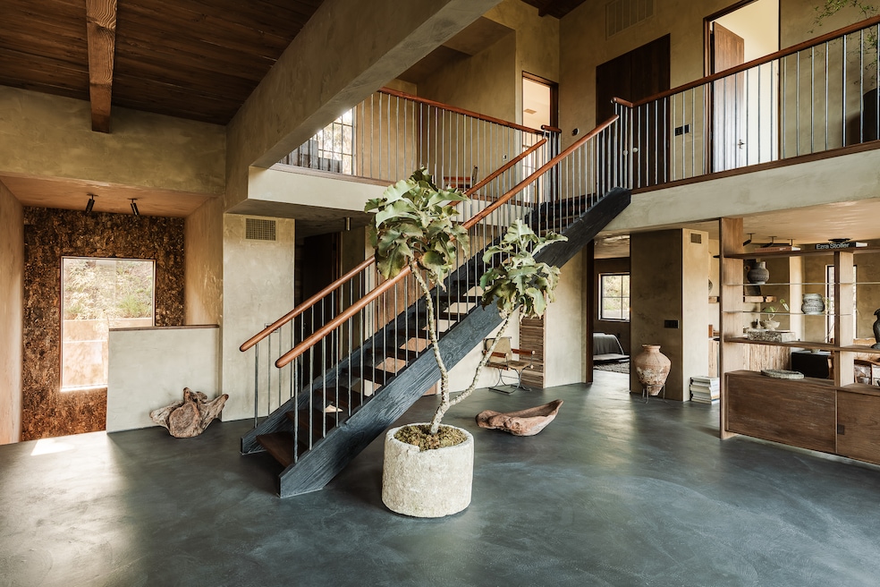 A steel-and-walnut staircase runs through the center. (Sterling Reed)
