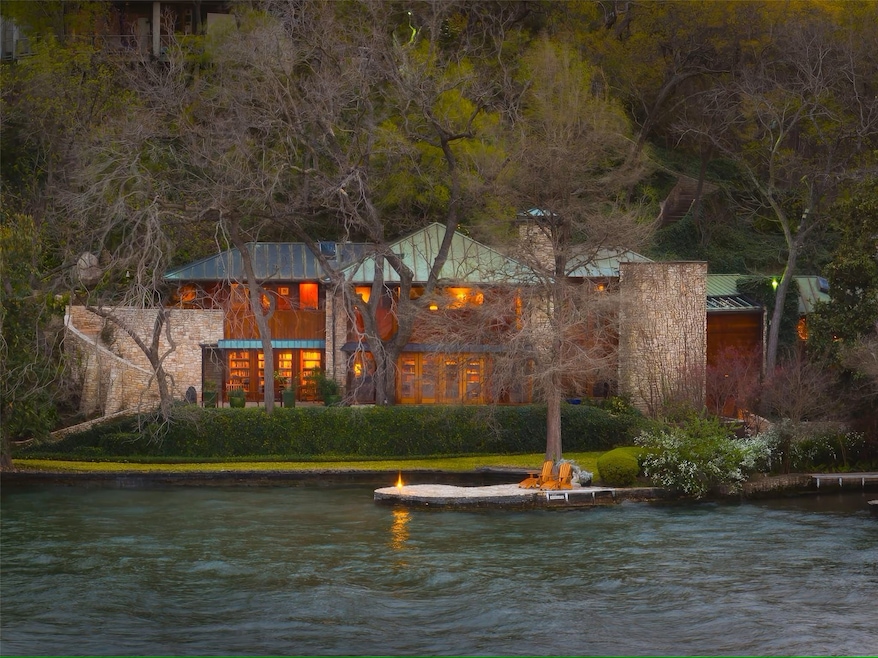 The wood-and-limestone exterior of the home stands out along the Lake Austin shoreline. (Moreland Properties via Homes.com)