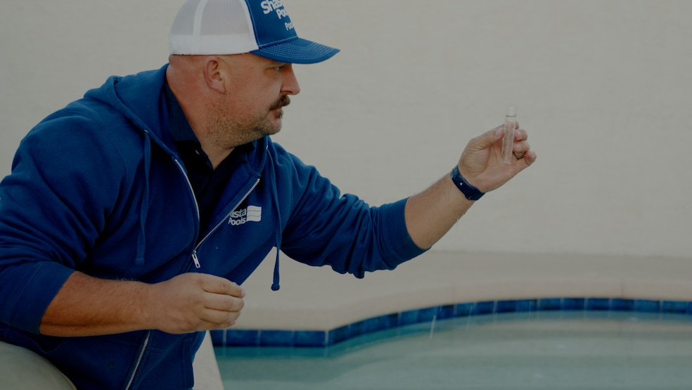 Brock Falk, pool care field manager at Shasta Pools. examines water chemicals at a pool he's servicing. (Proof Publicity)