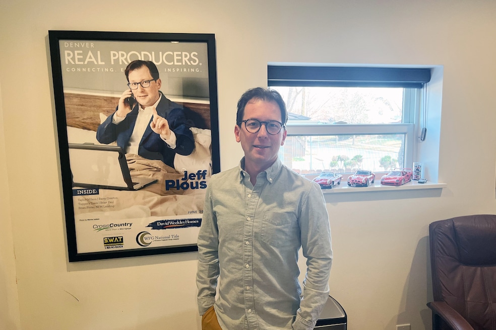 Agent Jeff Plous of Hatch Realty in his home office in the Sloan Lake neighborhood of Denver, Colorado. Plous said he always answers the phone and enjoys working from home — part of what inspired the photoshoot on the magazine behind him. (Caroline Broderick/Homes.com)