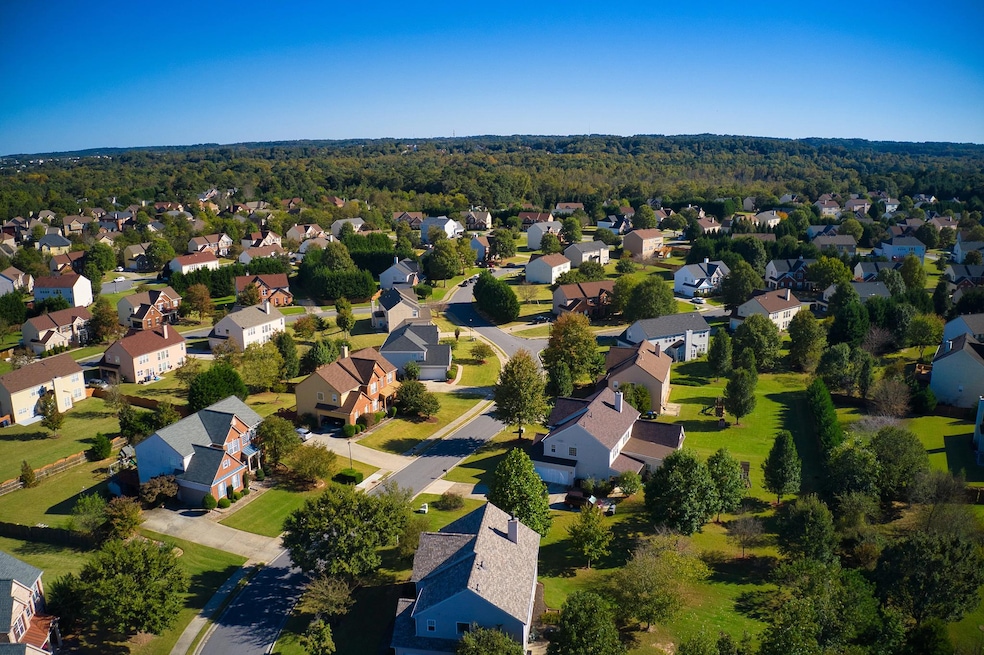 Shot using a drone during the golden hour shows an upscale suburbs with gold course, lake, houses and roof tops (Getty Images/iStockphoto)