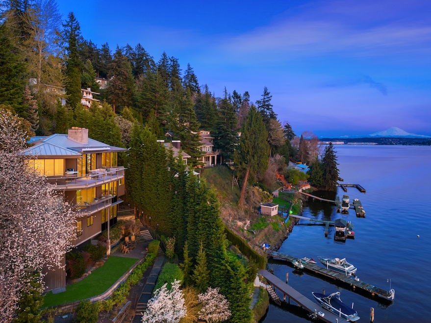 The Seattle residence, pictured on the left, sits on the edge of Lake Washington. The new owners will have access to the water, with a dock just steps below the house, and views of Mount Rainer. (John L. Scott Real Estate/Luxury Portfolio International)