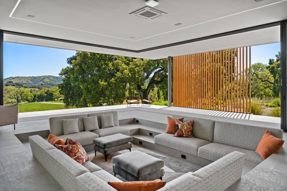 Retractable windows are one way the house embraces its proximity to the undeveloped land around it. (La Tierra Realty via Homes.com)