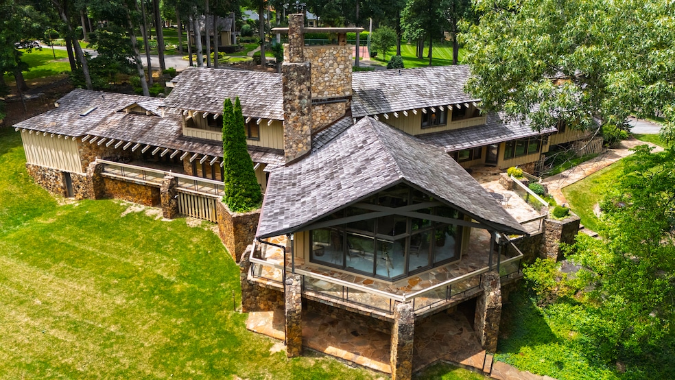 The living room features floor-to-ceiling windows, surrounded by a porch with stone quarried on the property. (Dominique Sinibaldi)