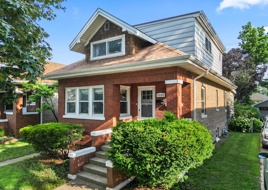 This bungalow for sale in Berwyn, Illinois, at 6948 30th St. includes waffle-textured brick and an expanded top-floor primary suite. (Chicago Real Estate Photography)