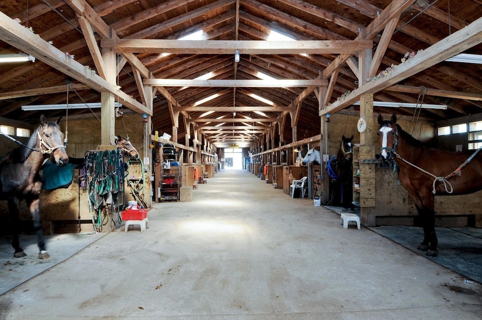 The home at 147 Eastport Manor on Long Island comes with a horse training track and a 55-stall barn. (Service Realty)