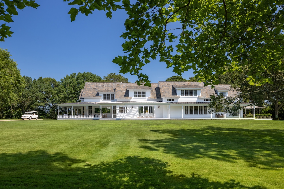 The 7,000-square-foot main house has a wraparound porch and faces a rolling lawn. (Evan Joseph / Evan Joseph Studios)