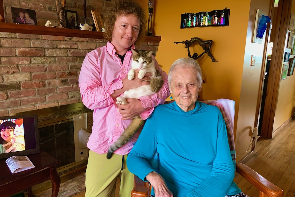 Charles DuGood holds his cat, Mazy, in the living room of Mickey Davis' Ferrisburgh, Vermont, home. (Katie Meade)