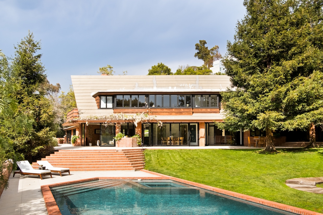 The window-lined residence sits at the end of a winding driveway on a 1.4-acre lot. (Engel Studios)
