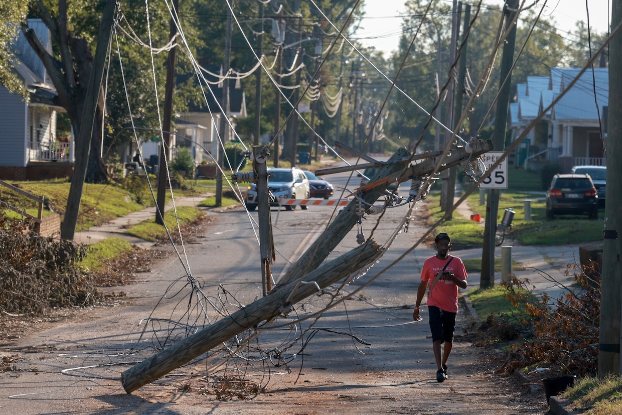 A person walks past downed power lines Oct. 5 in the aftermath of Hurricane Helene in Greenwood, South Carolina. (Joe Raedle/Getty Images)