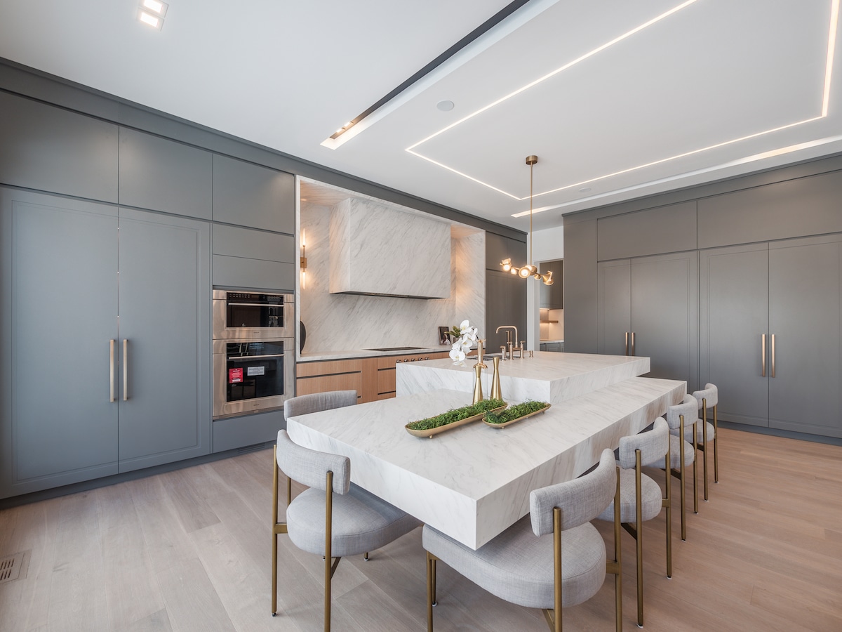 This minimalist kitchen Bahar Zaeem and Shima Radfar designed hides storage and appliances behind sleek cabinetry. The island makes a bold statement. (Ryan Fung Photography)