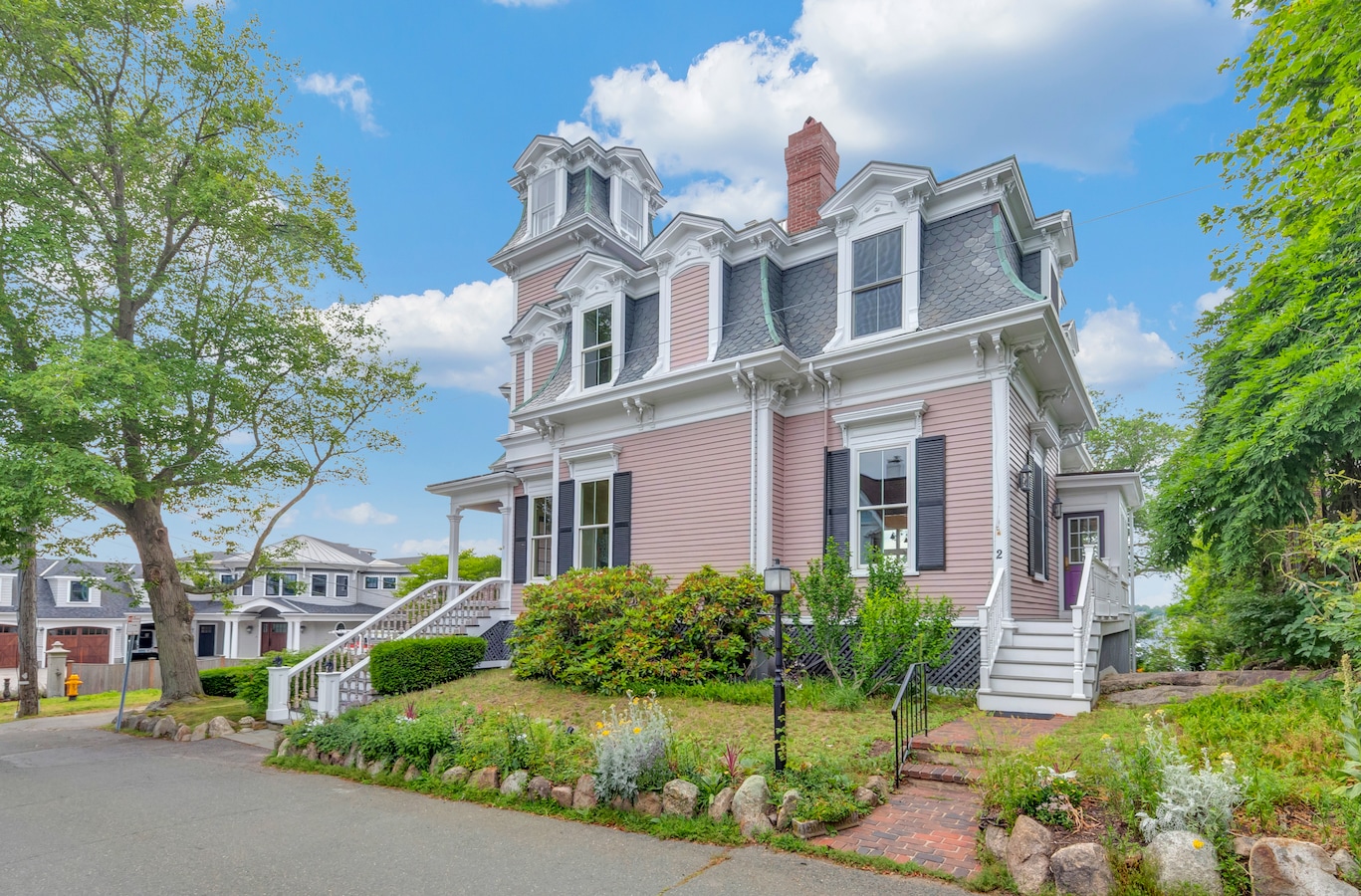The two-story property at 2 Clarendon St. in Gloucester, Massachusetts, features a mansard roof and covered porch. (Property Precision)