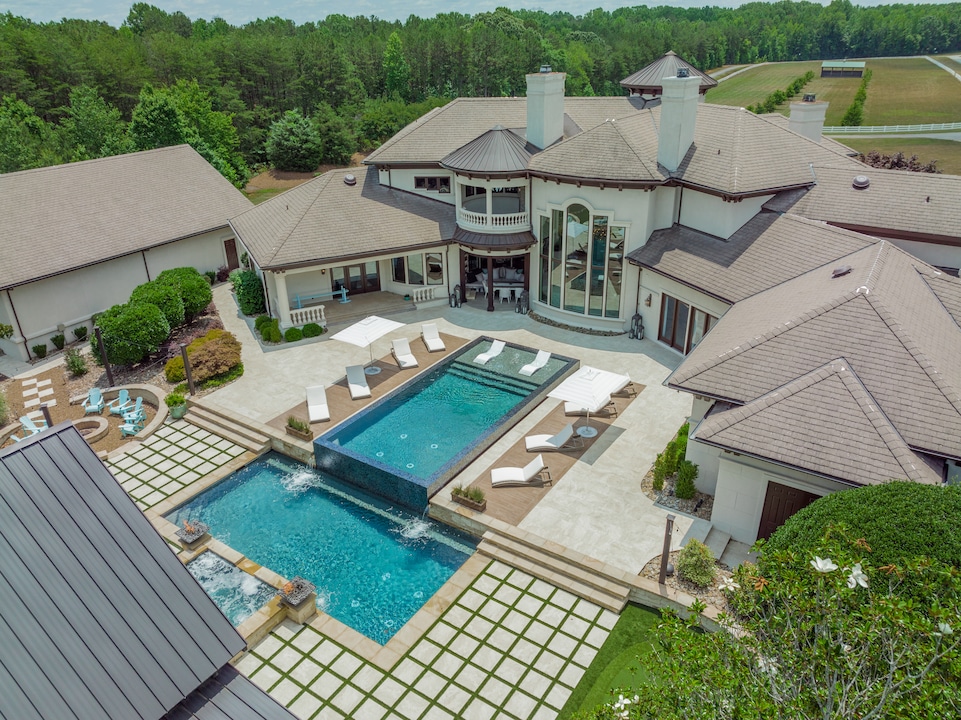 The main house looks out onto a vanishing-edge upper pool and adjacent pool house. (Cameron Glenn)