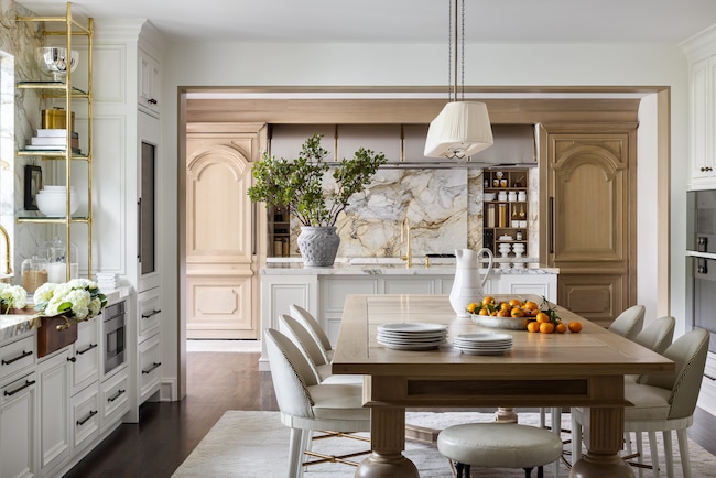 This more transitional-style kitchen Laura McCroskey designed offers a lot of square footage, featuring a combination of white and wood-stain cabinetry. The backsplash uses the same material as the countertop. (Nate Sheets Photography)